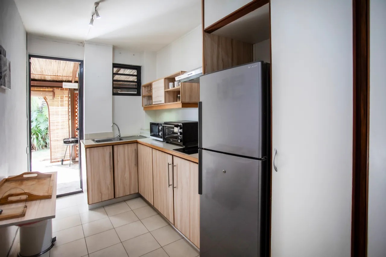 Cuisine avec plans de travail en bois et électroménager moderne.
