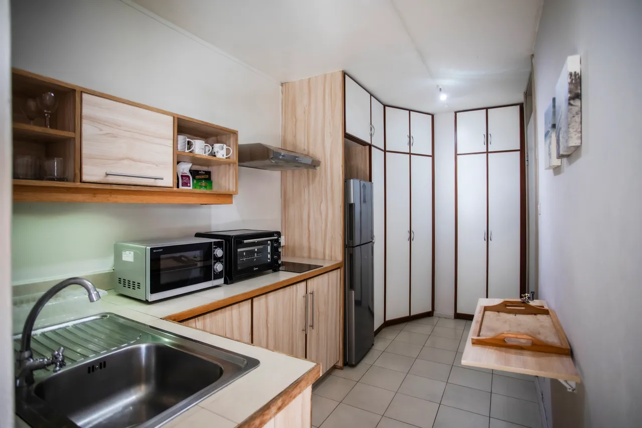 Cuisine avec armoires en bois et électroménager en acier inoxydable.