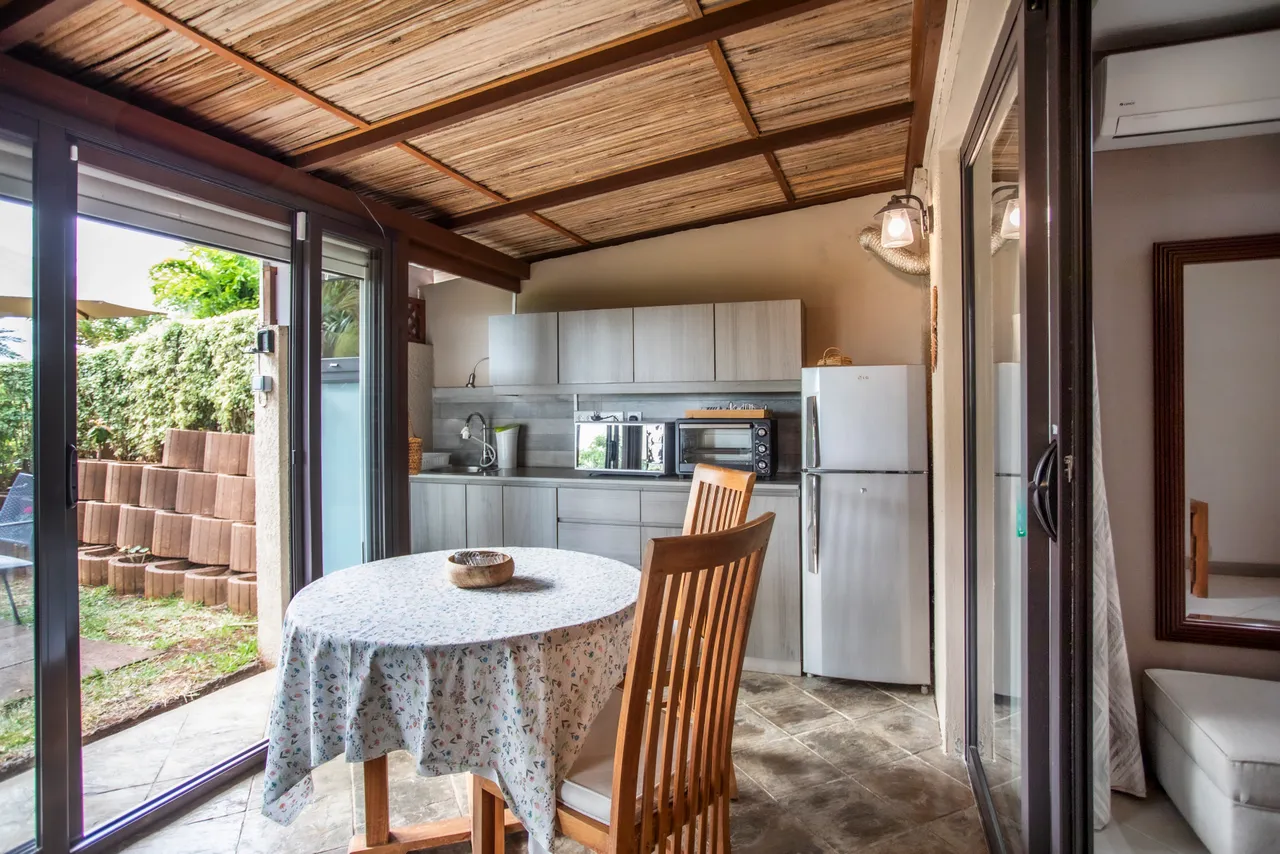 Cuisine ouverte sur la galerie, avec équipements modernes et mobilier en bois.