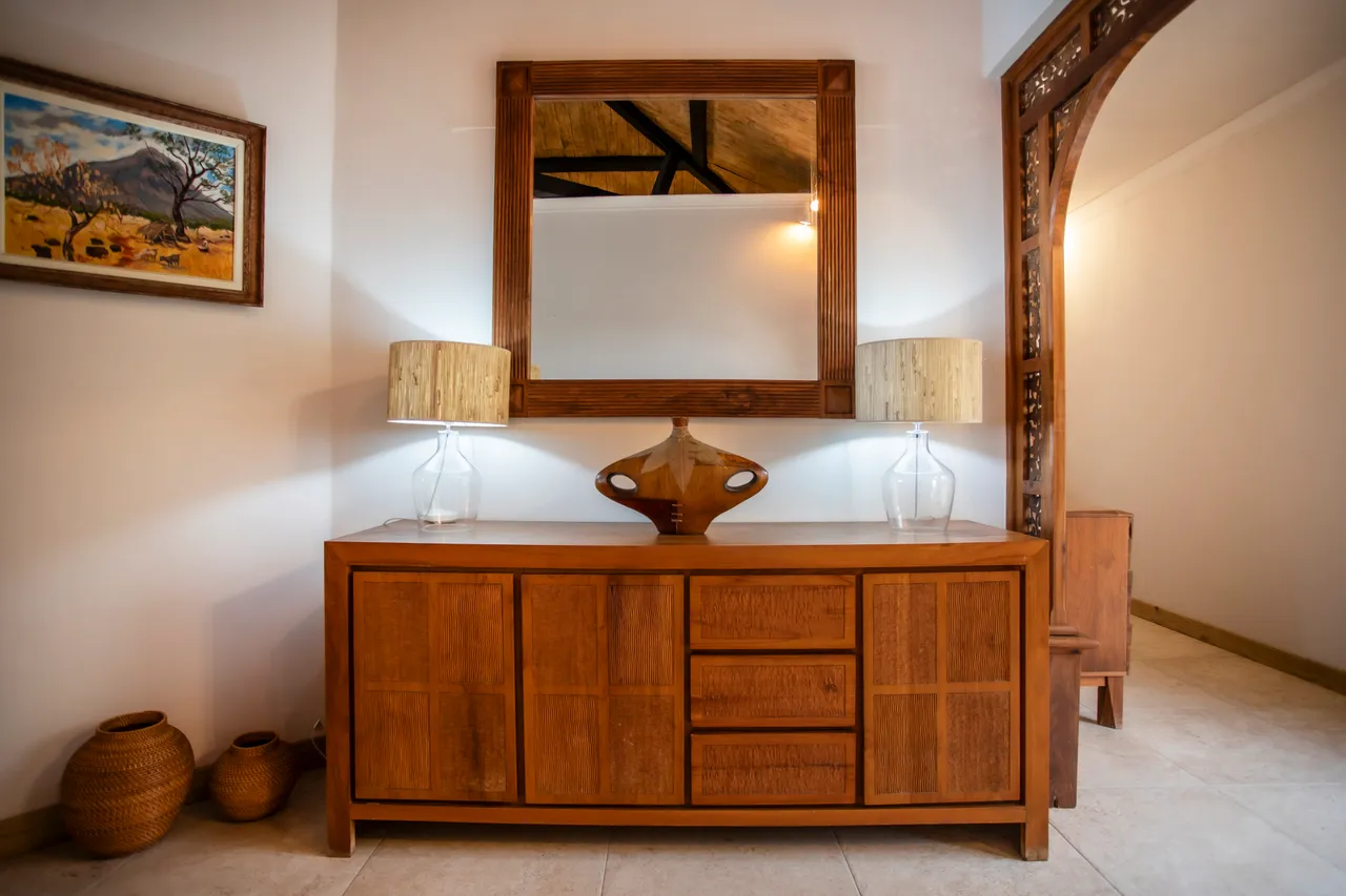 Console en bois avec miroir et lampes à poser en verre.
