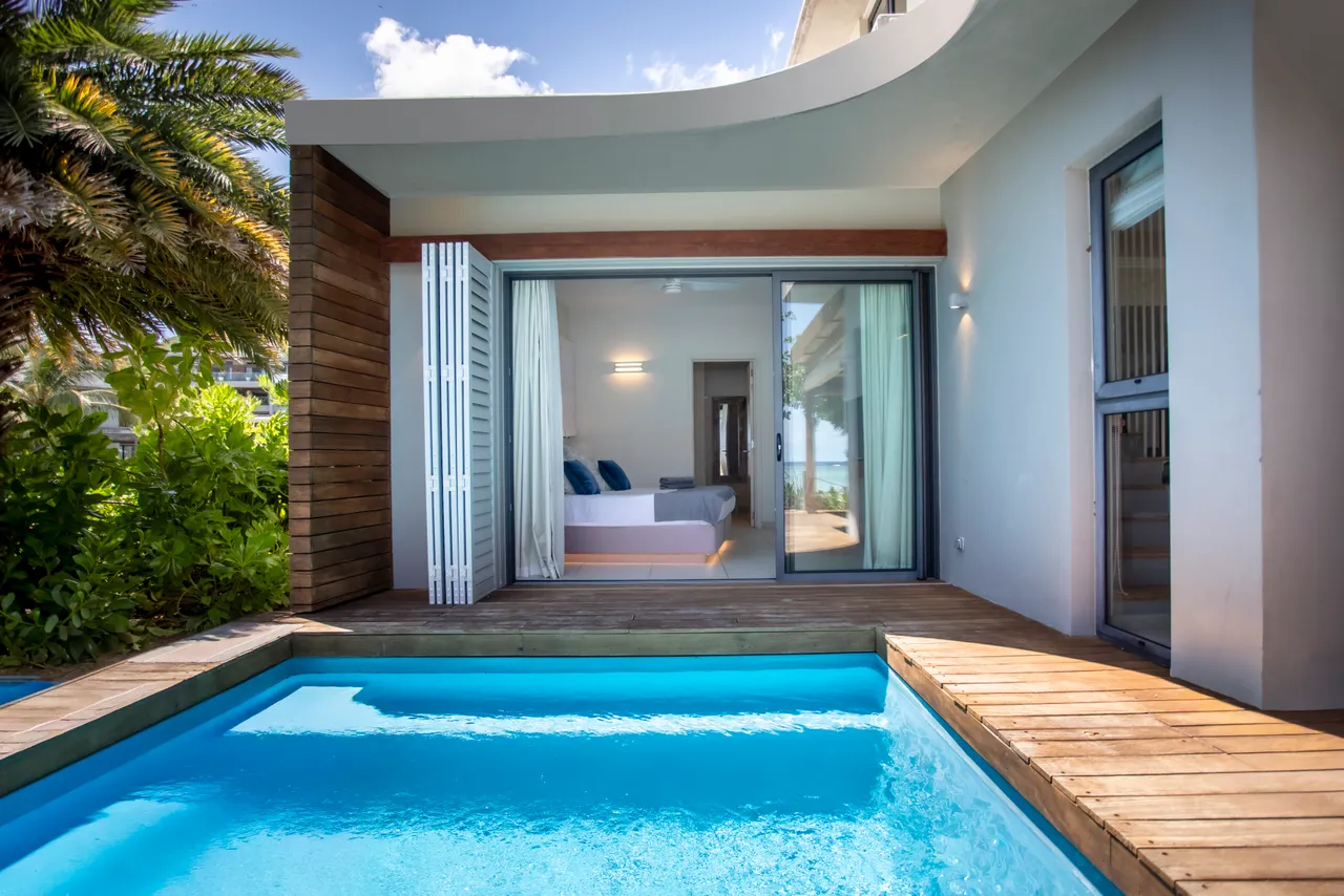 Piscine privée sur la terrasse, accessible directement depuis l'intérieur. Vues sur la végétation environnante. Mobilier en bois ajoutant une touche naturelle.