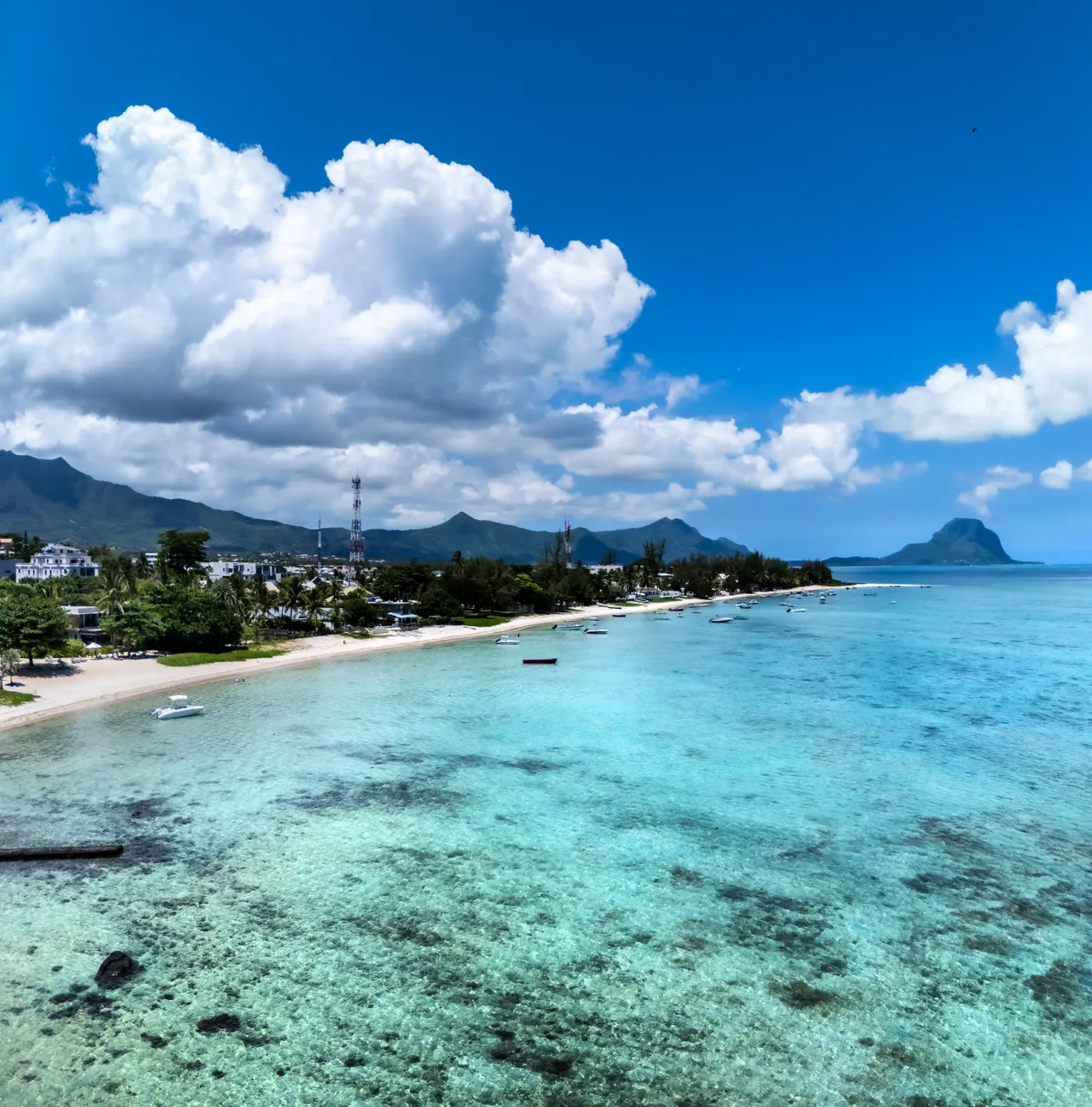 Vue panoramique sur la mer et la plage depuis la villa. Ciel dégagé et eaux turquoise. Plage accessible directement depuis la propriété.