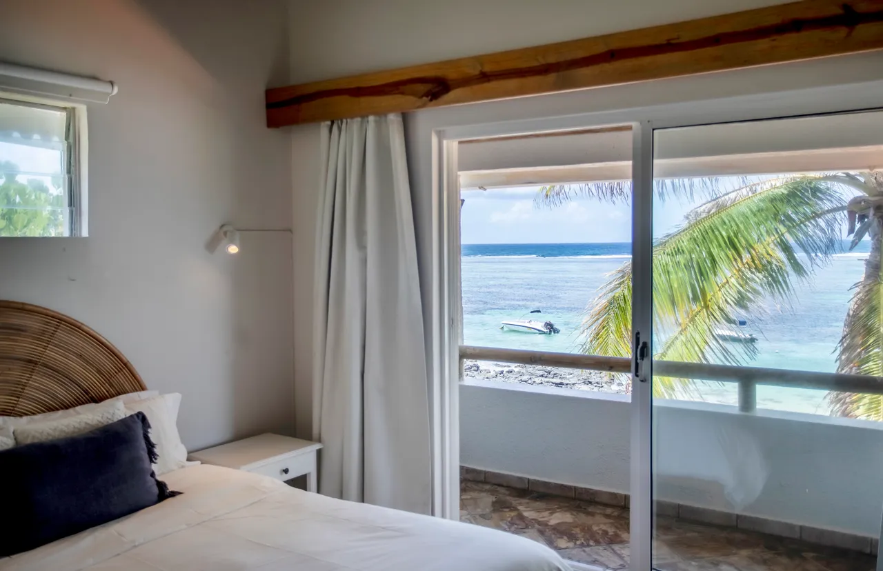 Chambre avec vue sur la mer, accès à un balcon. Décor sobre avec des teintes claires.
