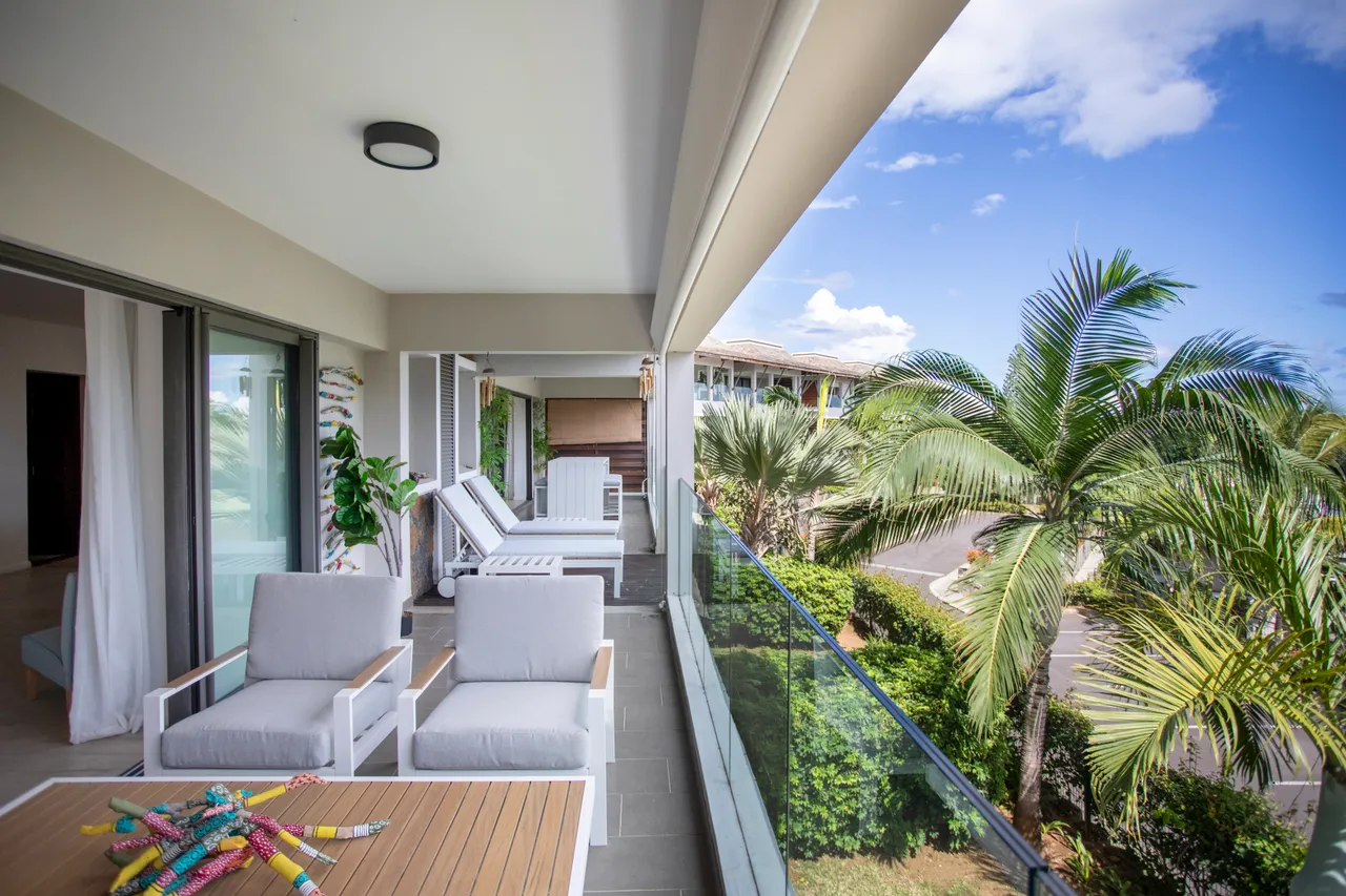 Terrasse avec mobilier moderne et vue dégagée sur le jardin.  
Espace extérieur lumineux grâce aux grandes baies vitrées.  
Décoration minimaliste ajoutant un aspect fonctionnel à l'agencement.  
Plantes en pot apportant une touche de verdure à l'environnement.  
Sol carrelé facilitant l'entretien et offrant un confort visuel.