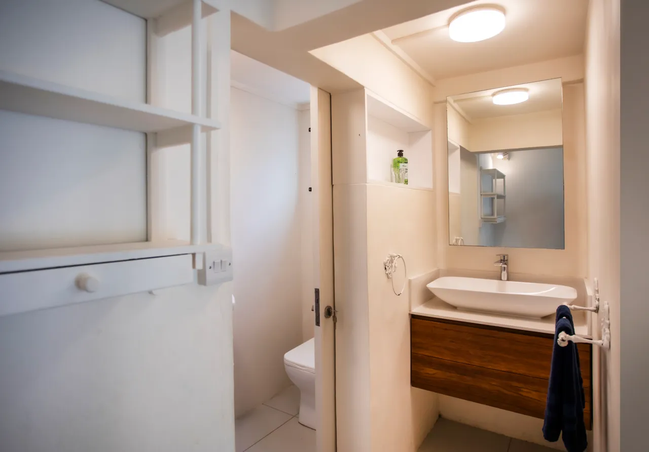 Salle de bain avec lavabo moderne et miroir éclairé. Espace compact et fonctionnel.