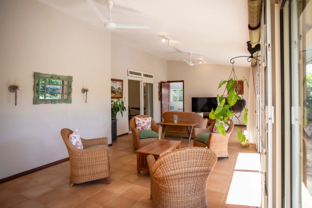 Espace ouvert avec ventilateurs au plafond et lumière naturelle. Accès direct au jardin.