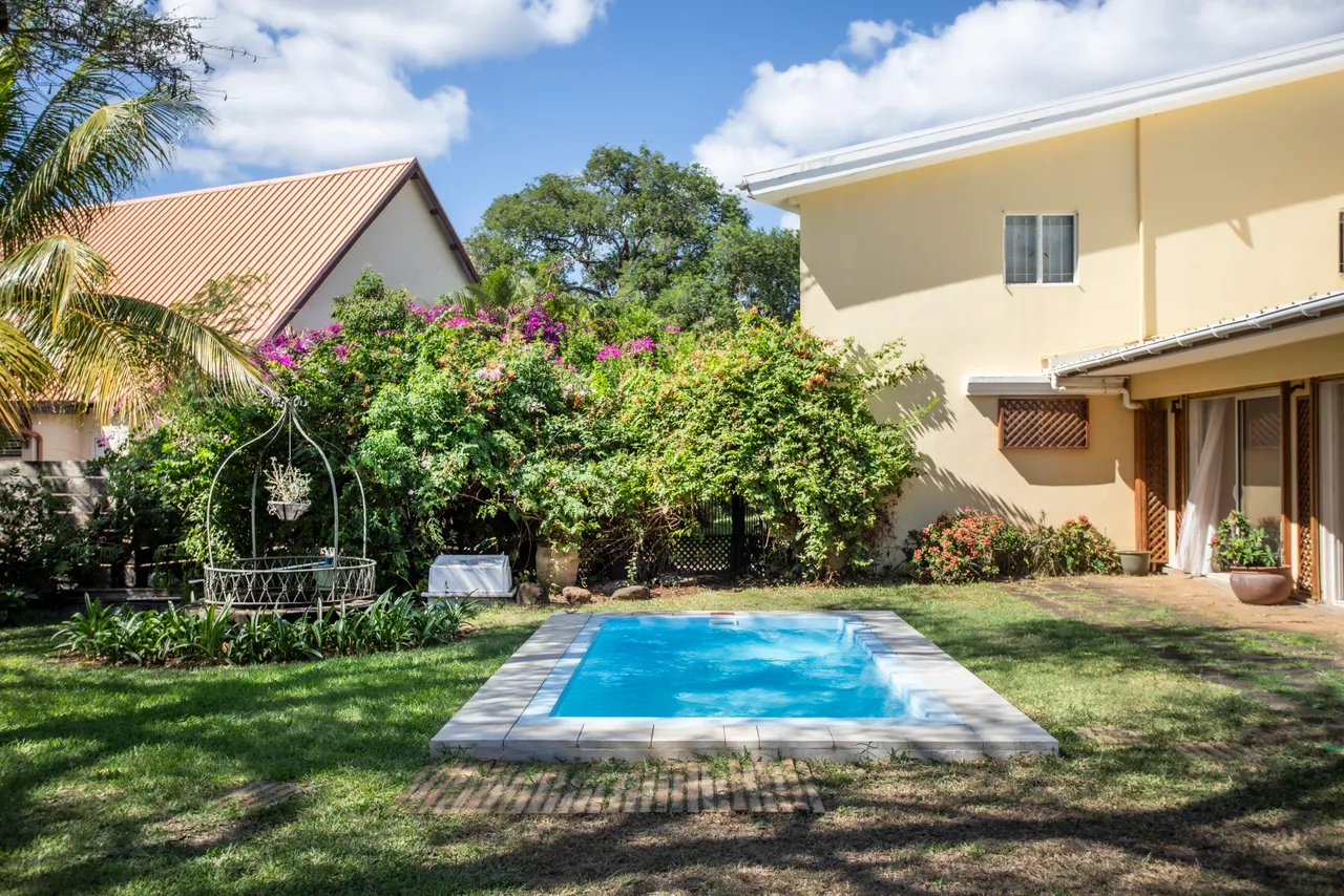 Bungalow avec piscine, entouré d'un jardin fleuri et verdoyant. Accès direct à la plage.