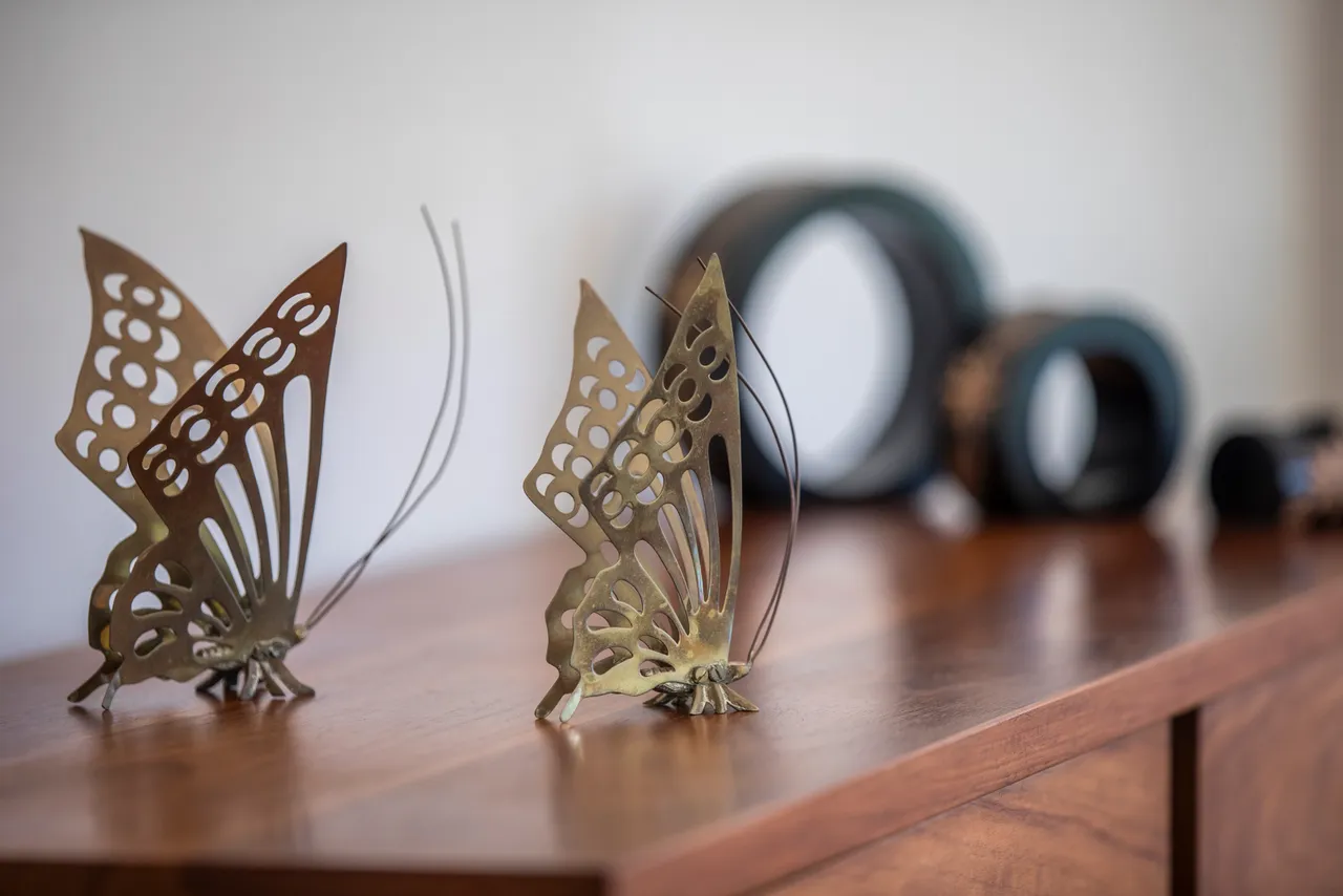 Décorations en métal en forme de papillons sur un meuble en bois.